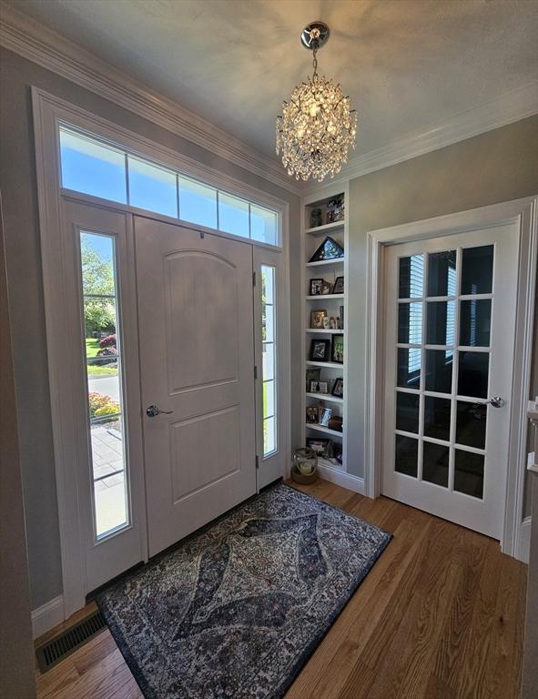 38 John Perkins Way, Middleboro, MA 02346 - entrance foyer with a chandelier, plenty of natural light, wood finished floors, and crown molding