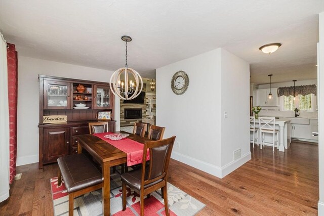 dining room featuring visible vents, baseboards, wood finished floors, and a chandelier