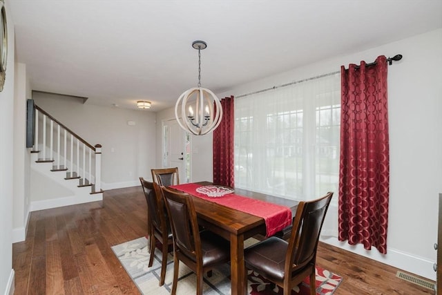 dining area featuring stairs, wood finished floors, a chandelier, and visible vents