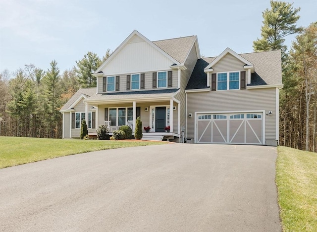 view of front of property with a front lawn, aphalt driveway, an attached garage, a porch, and roof with shingles