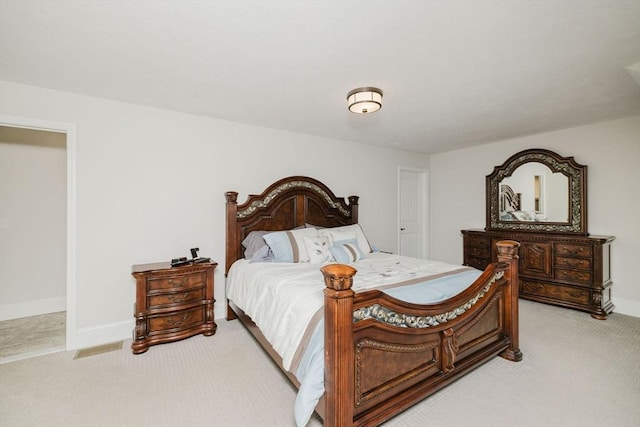 bedroom with baseboards and light colored carpet