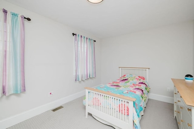 bedroom featuring baseboards and visible vents