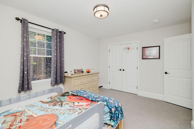 bedroom featuring baseboards, carpet flooring, and a closet