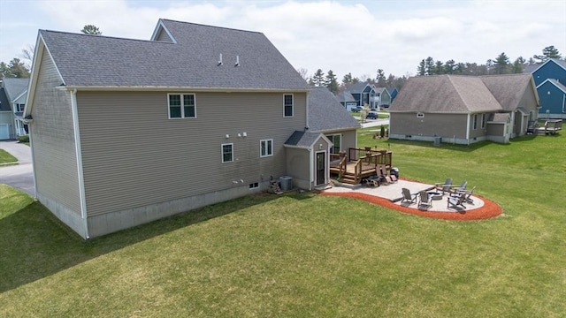 back of property featuring central AC, a patio area, a deck, a fire pit, and a yard