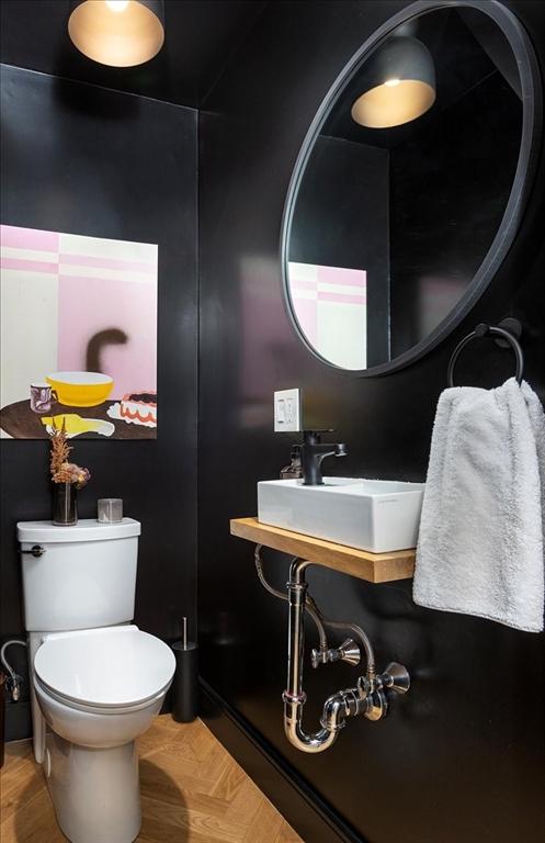 half bath featuring toilet and a sink
