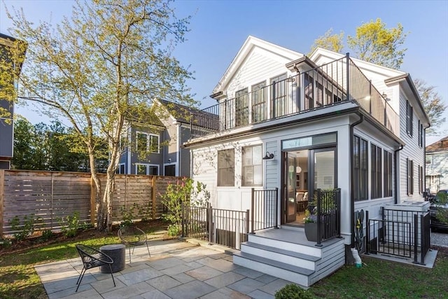 back of house featuring fence, a balcony, and a patio