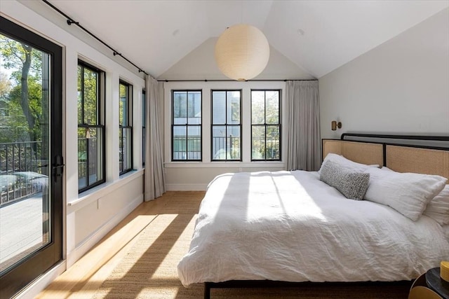 bedroom featuring lofted ceiling, wood finished floors, and baseboards