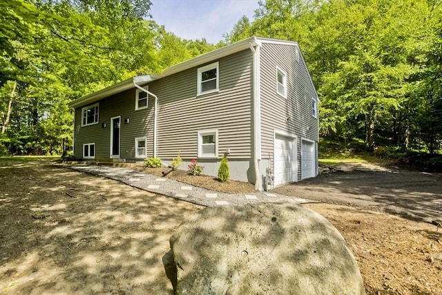 24 Old Jarvis Ave, Holyoke, MA 01040 - view of front of house featuring an attached garage, driveway, and view of scattered trees