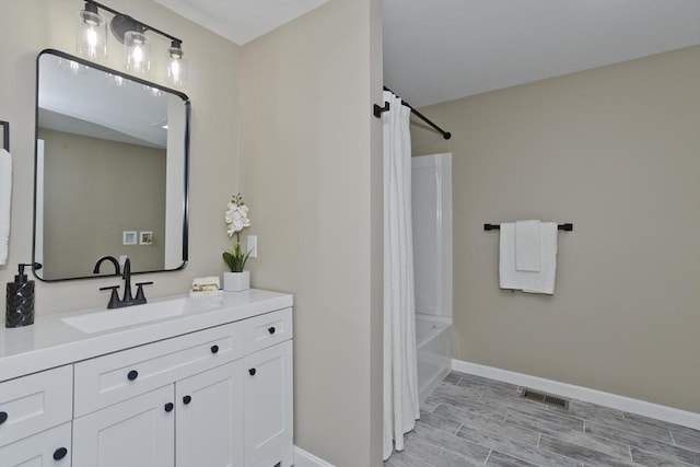 24 Old Jarvis Ave, Holyoke, MA 01040 - full bath with vanity, baseboards, shower / bath combo with shower curtain, and wood finished floors