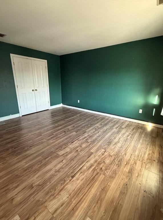 unfurnished bedroom with hardwood / wood-style floors and a closet