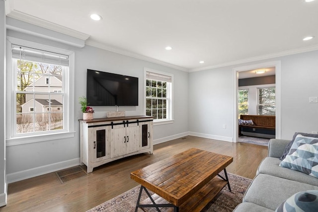 living area featuring plenty of natural light, wood finished floors, and visible vents