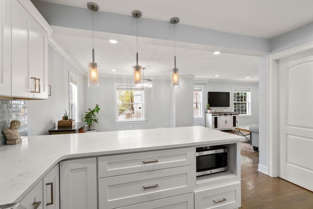 kitchen featuring dark wood-style flooring, white cabinets, stainless steel microwave, a peninsula, and recessed lighting