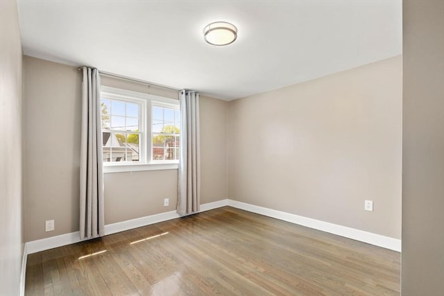 empty room featuring baseboards and wood finished floors