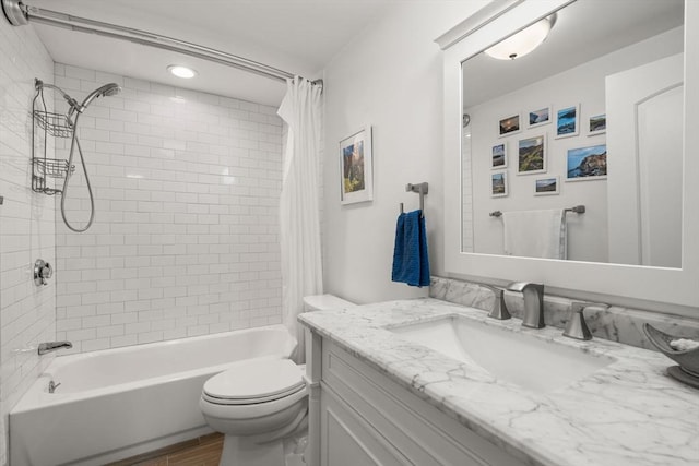 bathroom featuring toilet, wood finished floors, shower / bath combo, and vanity