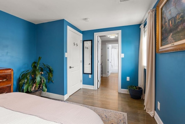 bedroom with baseboards and wood finished floors