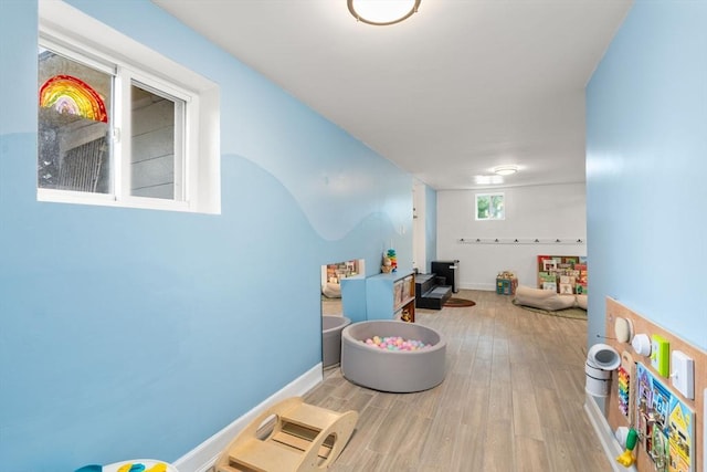 game room with baseboards and wood finished floors