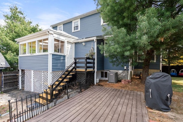 deck with fence, central air condition unit, and stairway