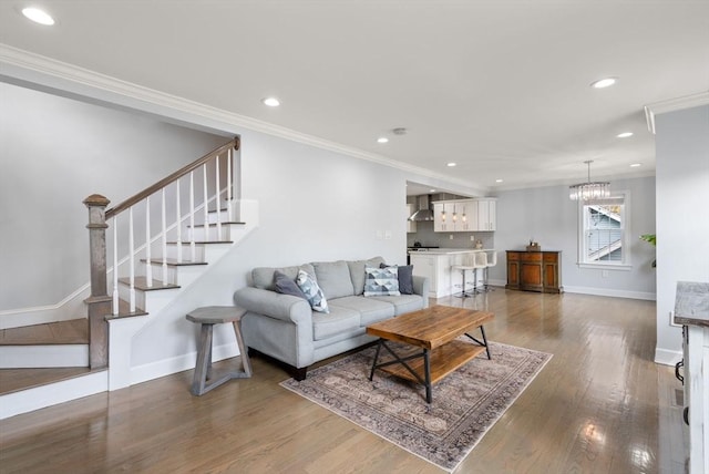 living area with crown molding, wood finished floors, baseboards, stairway, and recessed lighting