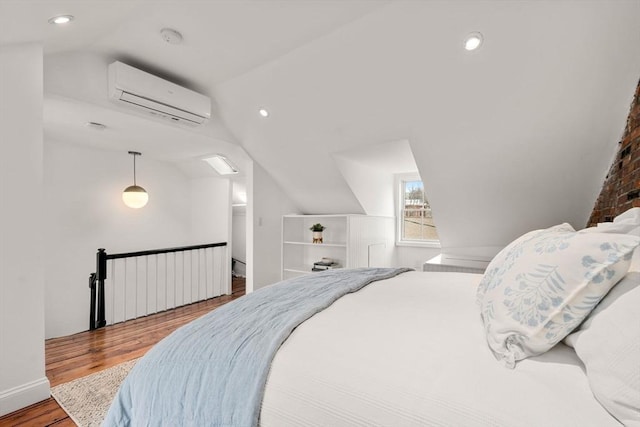 bedroom with recessed lighting, wood finished floors, vaulted ceiling, and a wall mounted AC