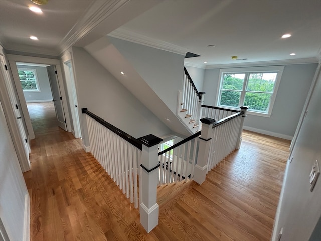 staircase featuring ornamental molding, hardwood / wood-style flooring, and plenty of natural light