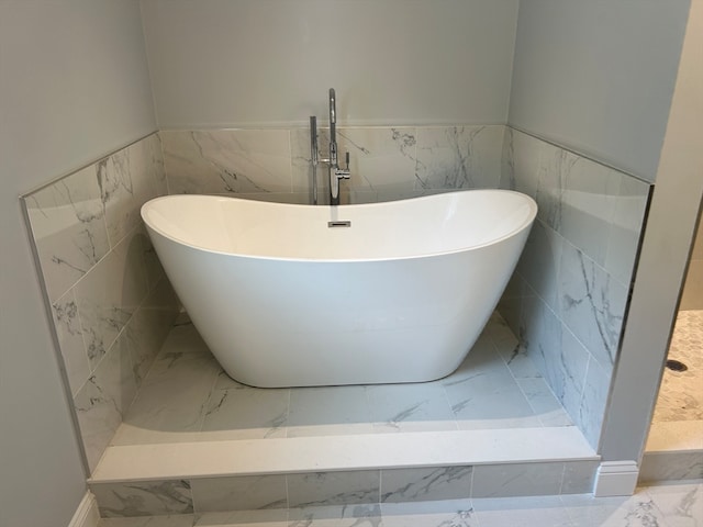 bathroom with tile walls and a bathtub