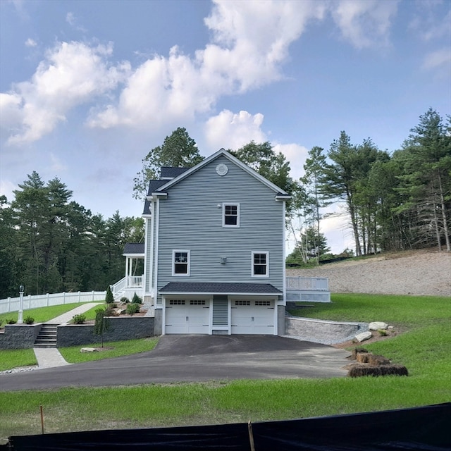 rear view of house featuring a yard and a garage