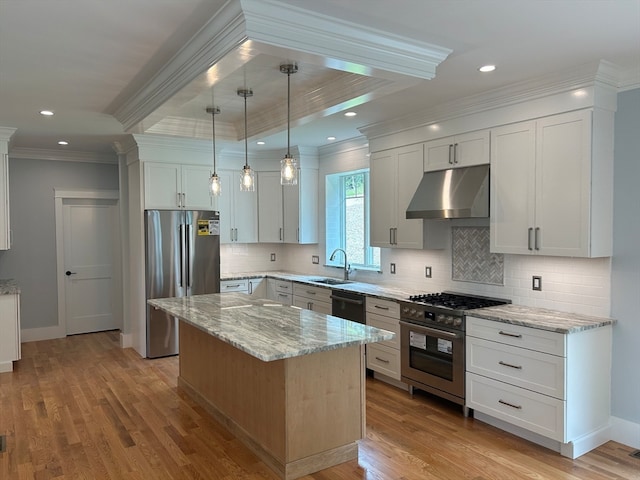 kitchen featuring appliances with stainless steel finishes, a center island, light hardwood / wood-style flooring, and white cabinets