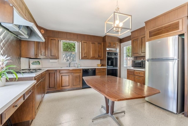 22 Adams Ave, Watertown, MA 02472 - kitchen with under cabinet range hood, light countertops, brown cabinetry, black appliances, and a sink