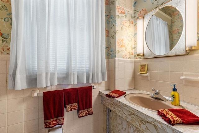 22 Adams Ave, Watertown, MA 02472 - bathroom featuring wallpapered walls, tile walls, wainscoting, and a sink