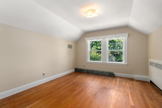 22 Adams Ave, Watertown, MA 02472 - additional living space featuring vaulted ceiling, light wood-style flooring, radiator, and visible vents