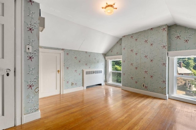 22 Adams Ave, Watertown, MA 02472 - additional living space with light wood-style floors, radiator, vaulted ceiling, and wallpapered walls