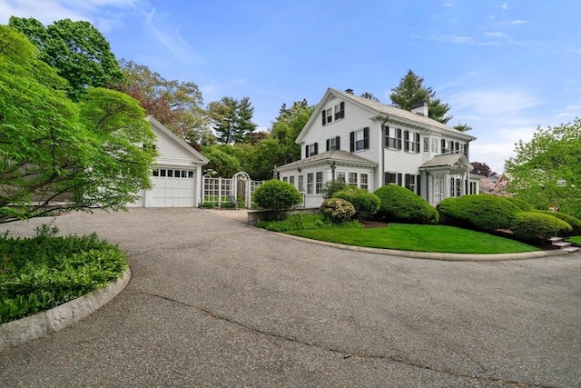 22 Adams Ave, Watertown, MA 02472 - view of front of property featuring a gate, a chimney, a front lawn, a garage, and aphalt driveway