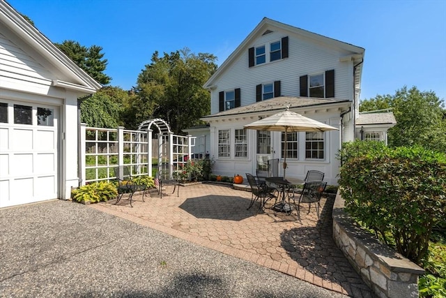 22 Adams Ave, Watertown, MA 02472 - back of property with a patio area and a garage