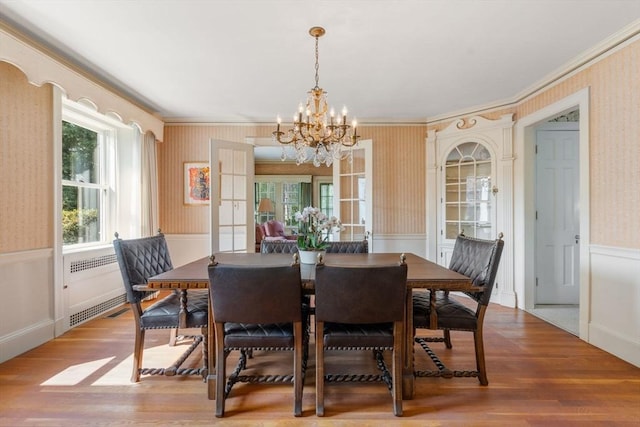 22 Adams Ave, Watertown, MA 02472 - dining room featuring a wainscoted wall, wallpapered walls, crown molding, and wood finished floors