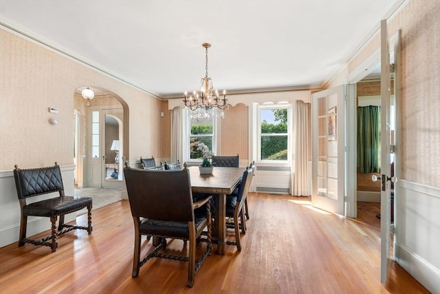 22 Adams Ave, Watertown, MA 02472 - dining area with an inviting chandelier, crown molding, arched walkways, and light wood finished floors