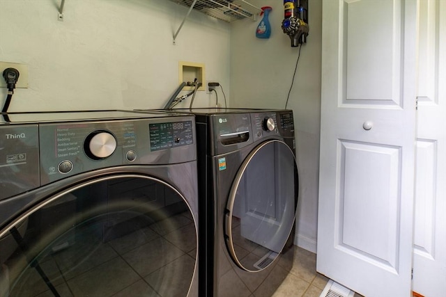 washroom featuring washer and clothes dryer and light tile patterned floors