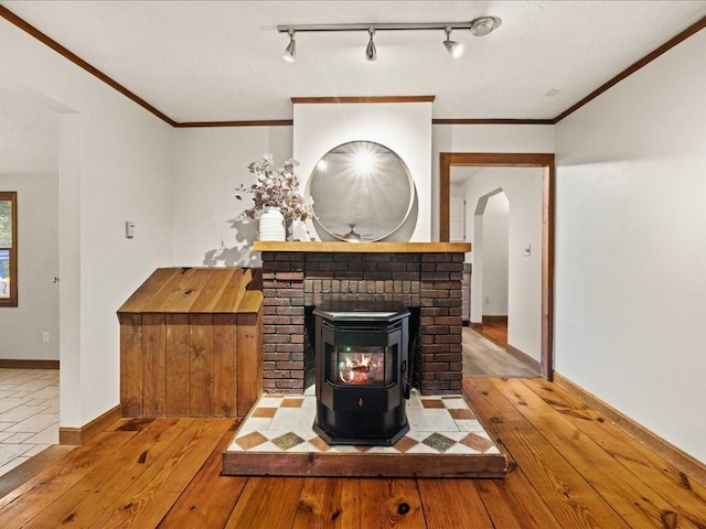 unfurnished living room with ornamental molding, light hardwood / wood-style flooring, and a wood stove