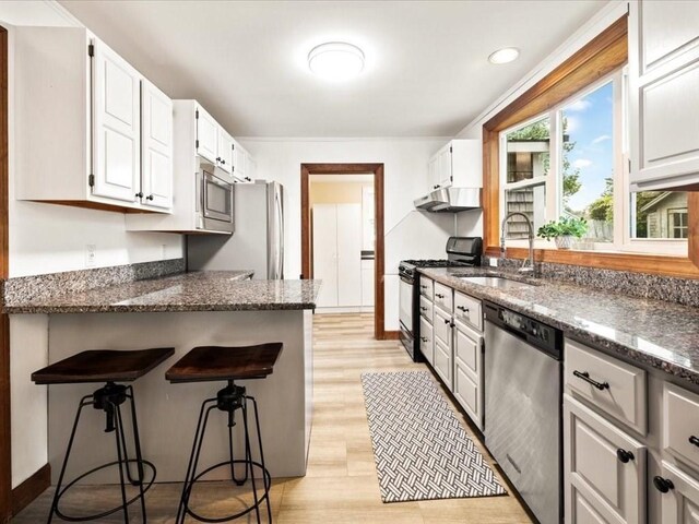 kitchen featuring white cabinets, dark stone counters, and appliances with stainless steel finishes