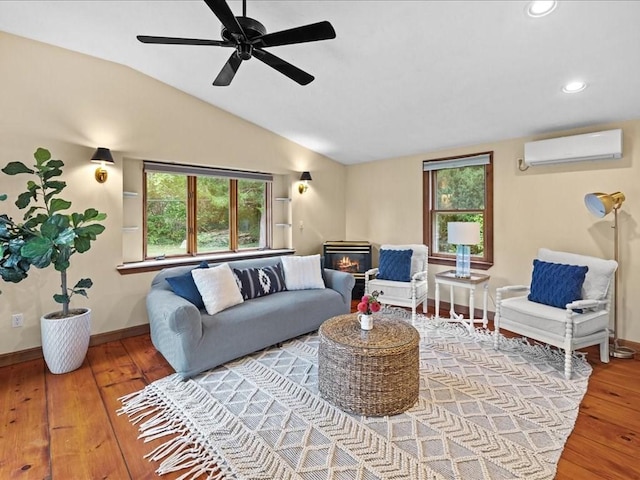 living room featuring a wealth of natural light, a wall mounted air conditioner, lofted ceiling, and hardwood / wood-style flooring