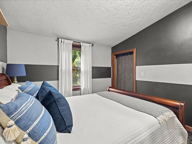 bedroom with lofted ceiling and a textured ceiling