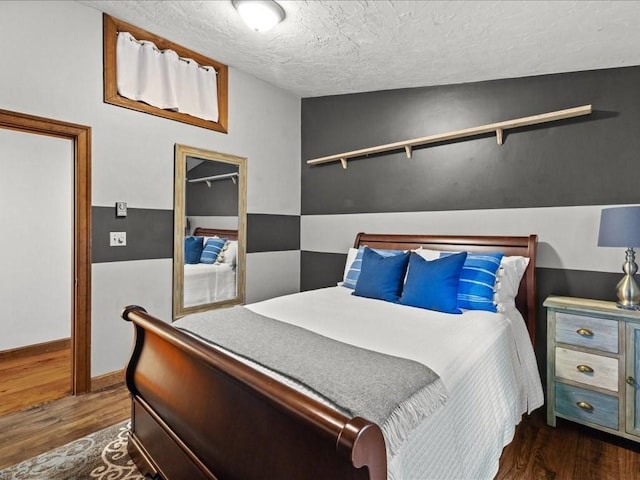 bedroom featuring a textured ceiling, vaulted ceiling, and dark hardwood / wood-style floors