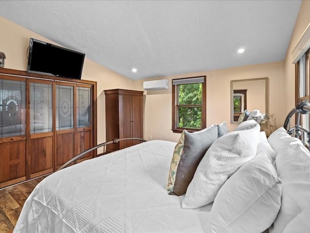 bedroom with a closet, hardwood / wood-style flooring, and a wall mounted air conditioner