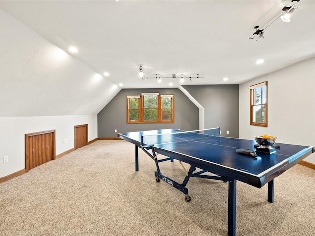 recreation room featuring vaulted ceiling, rail lighting, and carpet