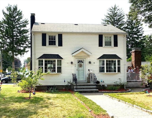 colonial-style house featuring a front lawn