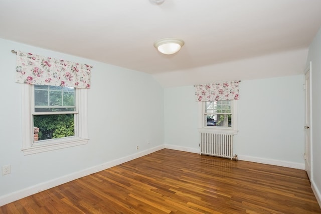 unfurnished room featuring radiator, lofted ceiling, and wood-type flooring