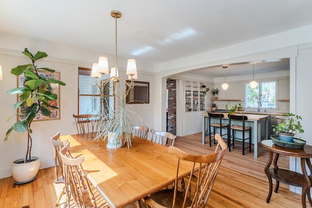 dining area featuring light wood-style floors and an inviting chandelier