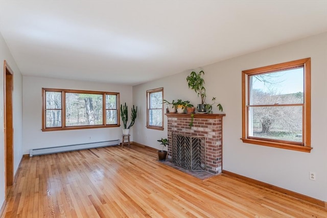 living room with a baseboard heating unit, baseboards, a fireplace, and light wood-type flooring