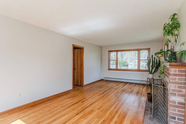 unfurnished living room with a baseboard heating unit, a fireplace, light wood finished floors, and baseboards