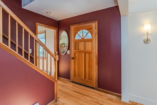 foyer featuring light wood-type flooring, baseboards, and stairs