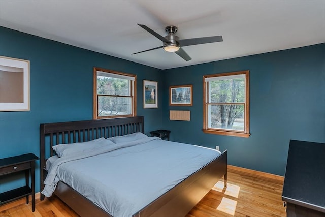 bedroom with baseboards, a ceiling fan, and wood finished floors